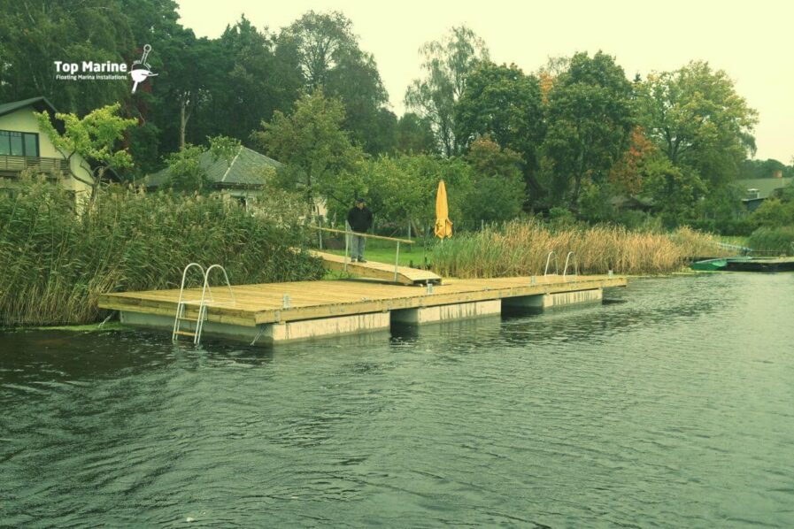 Betoniponttonilaituri puukannella ja uimaportailla mökkirannassa