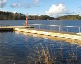 Rantalinna betoniponttoonilaituri kaiteilla rannassa